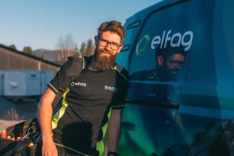 Elfaag servicetekniker med elfag logo, står ved varebil, klar for elektriske installasjoner og service i Norge.
